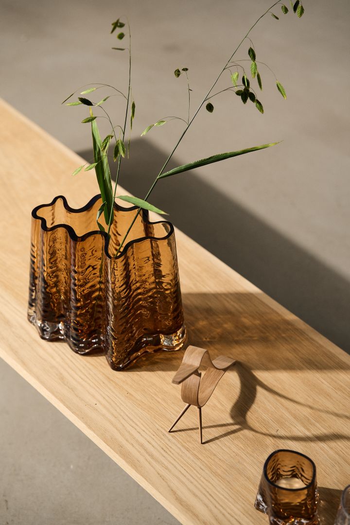 Coloured glass continues to be a strong trend, even in autumn 2023 interior design trends and can be seen in vases such as this wavy brown glass vase from Cooee Design. 