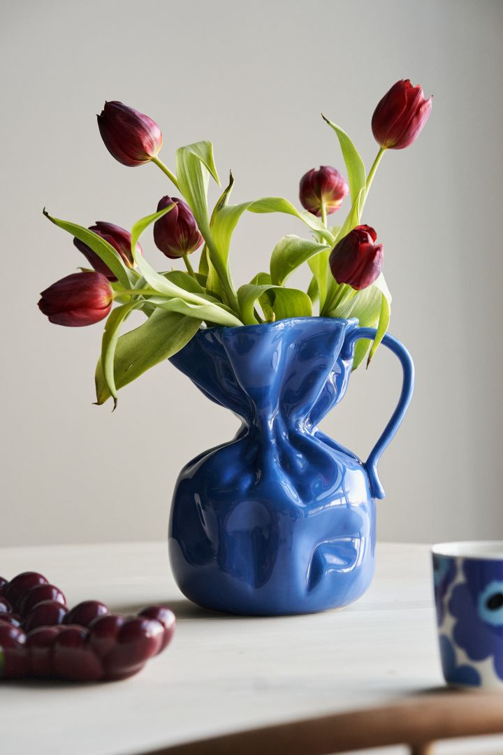 Follow the autumn 2023 interior design trends and make your interior pop with cornflower blue accents - here the Crumble vase from By On with red tulips. 