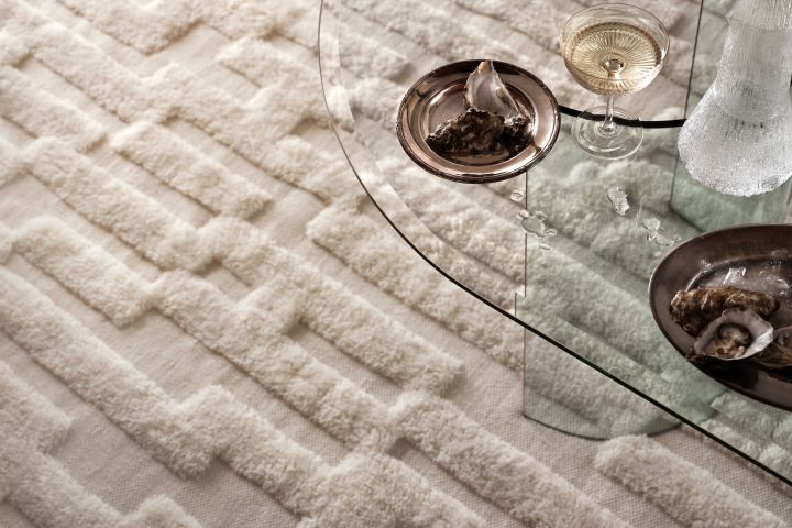 A white wool rug with a raised pattern from Swedish design brand Tinted Objects. 