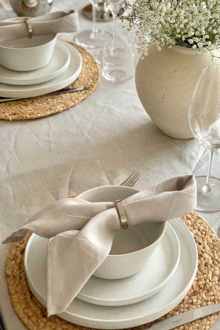 A simple napkin fold for a dinner party sitting on top of a white bowl. 
