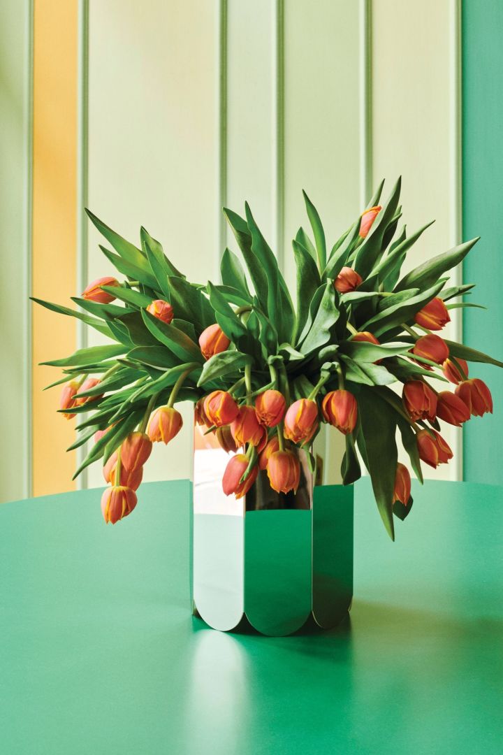 Spring 2024 interior design trends include chrome details and statement pieces, like HAY's Arc mirrored glass vase.
