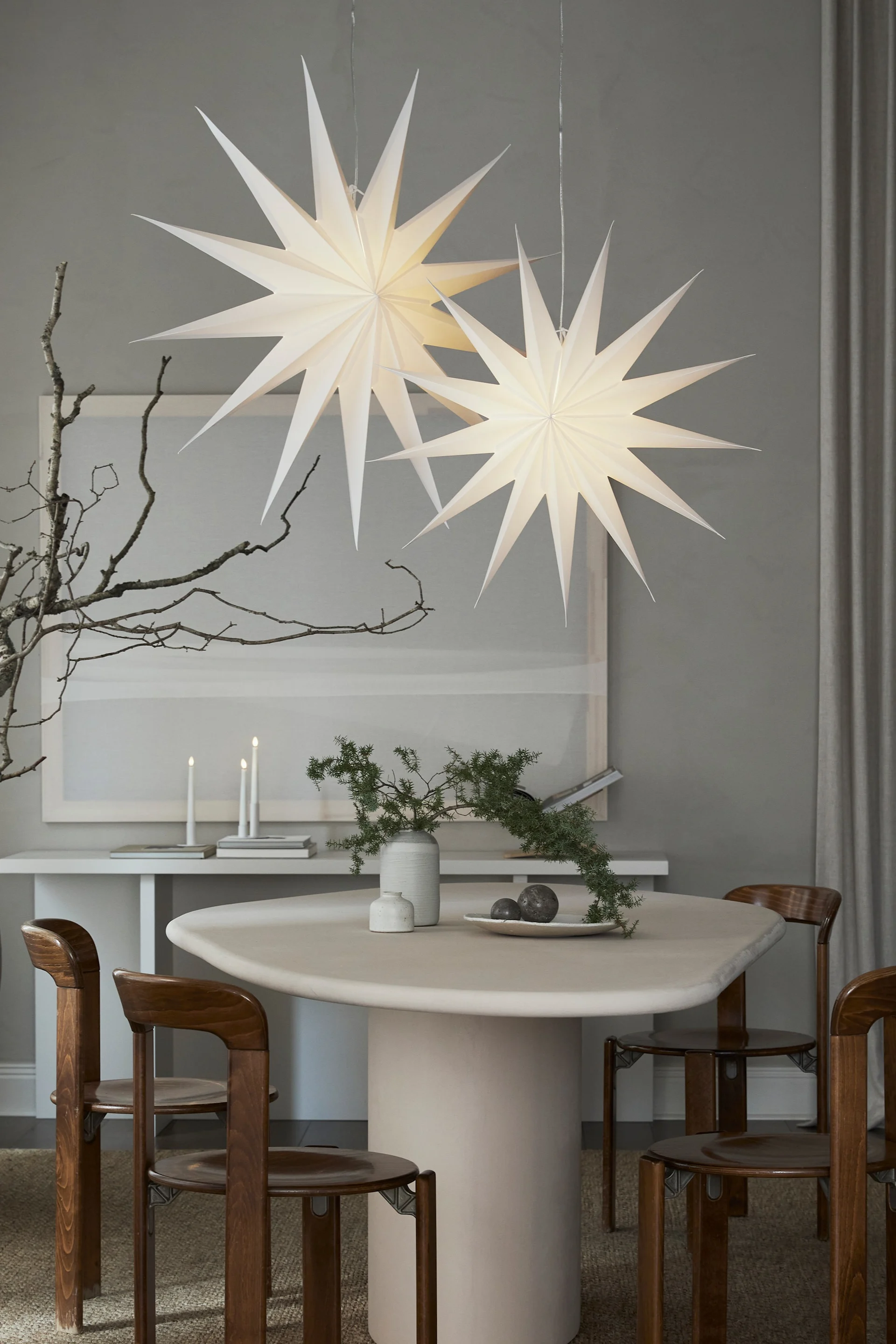 The Christmas paper star lantern Vivi from Watt & Veke hanging over a small dining table. 