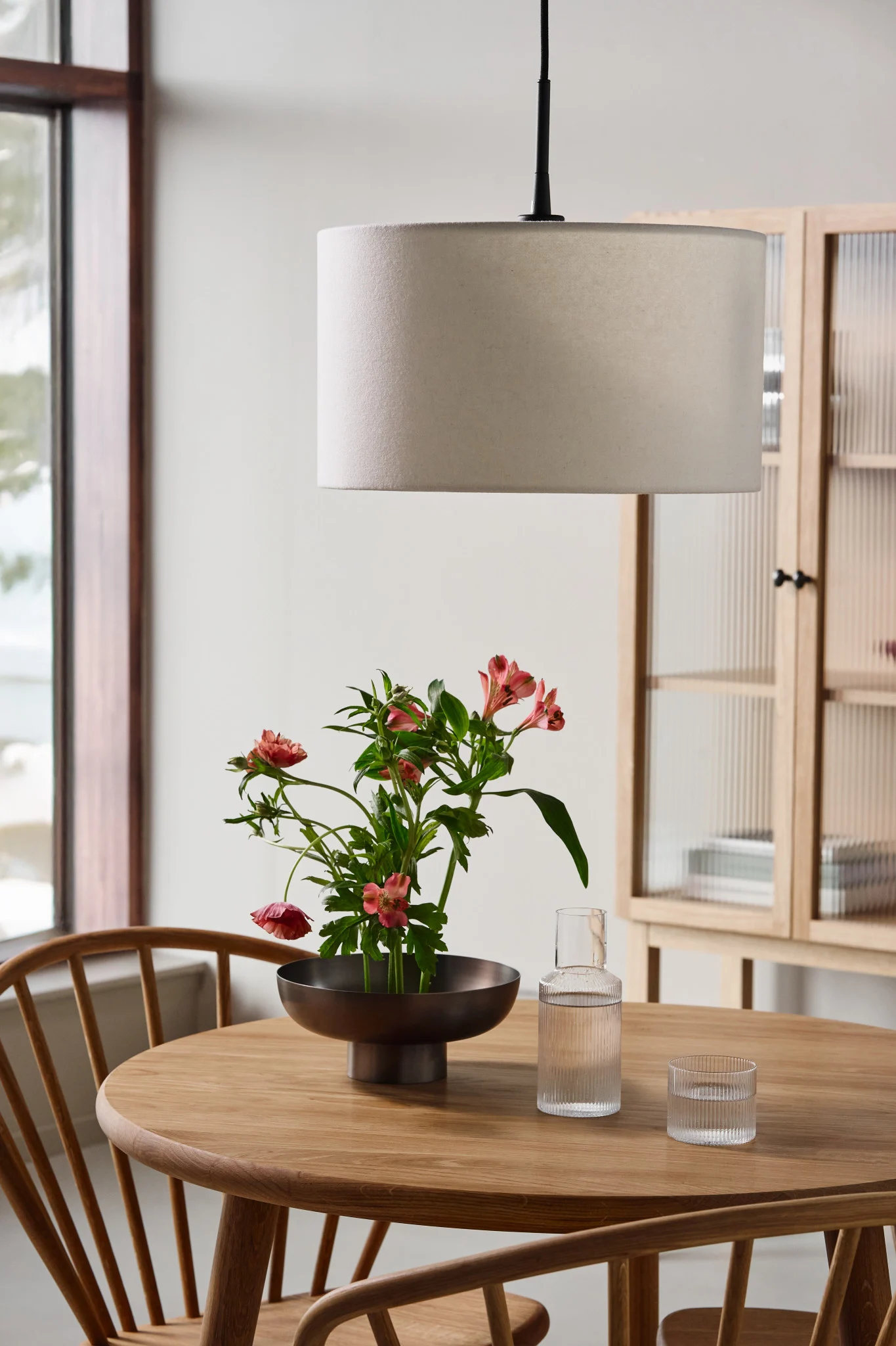 Dining room lighting ideas to highlight the dining table. Here you see the Soft pendant lamp from Belid hanging over the a wooden dining table. 