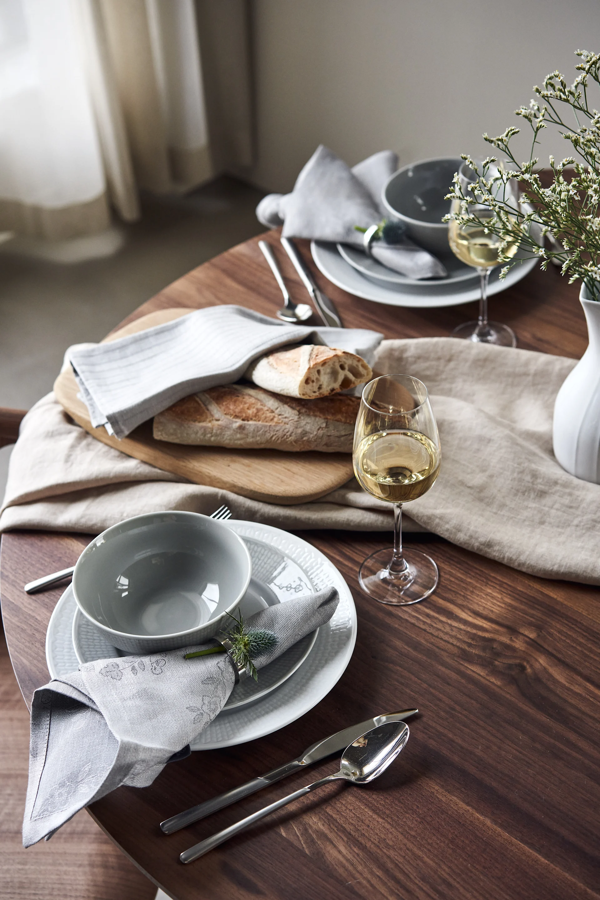 Swedish Grace table set with bowl and plates in cool shades of grey and white. 