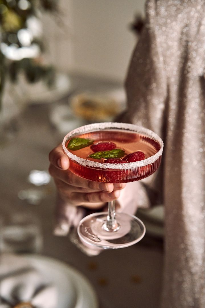 Different types of cocktail glass and used for different types of cocktails. Here you see a hand holding the Ripple coupe glass from ferm LIVING. 