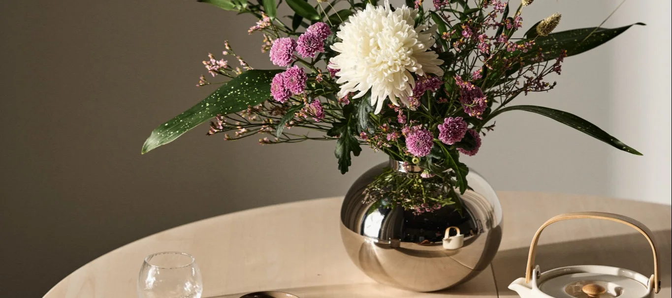 The Alvar Aalto vase from Iittala stands on a sideboard, the best vase for cut flowers.