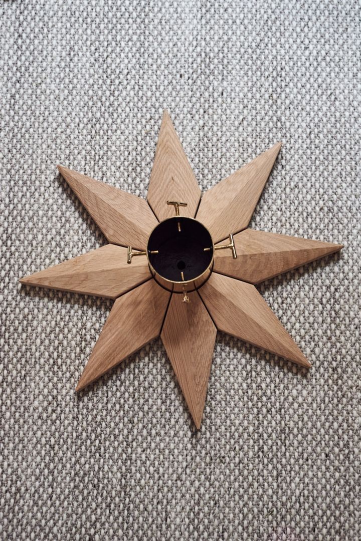 Christmas tree base in oak and brass from Skagerak fits perfectly into minimalist Christmas decor.