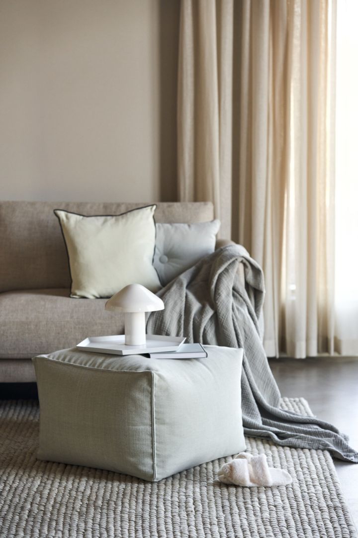 The Crinkle throw in grey and the Pao portable lamp from HAY in a neutral living room. 
