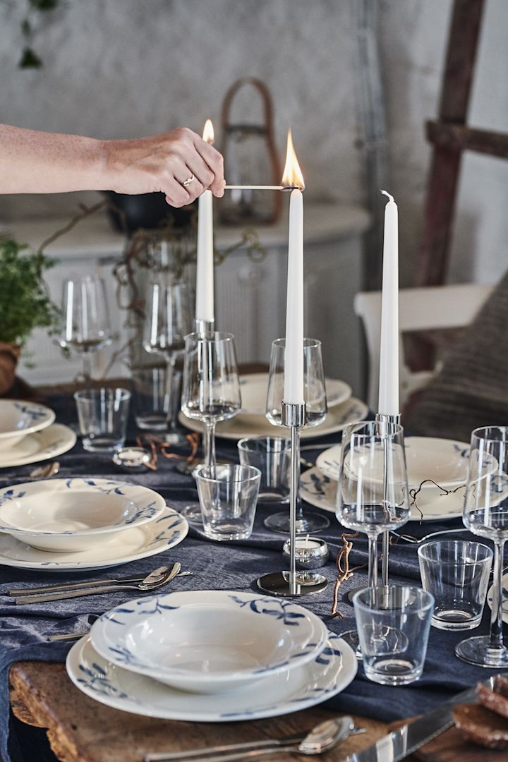 An elegant table setting idea with tall candles and a pop of blue from the Havspil collection from Scandi Living.