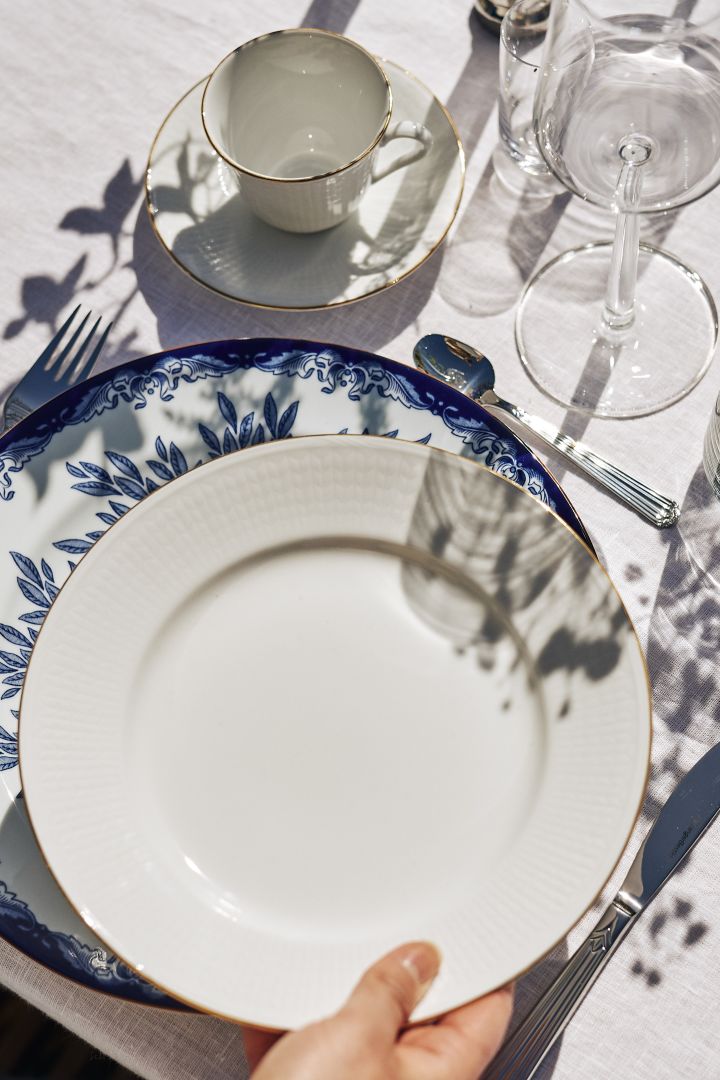 An elegant table setting idea with tall candles and a pop of blue from the Havspil collection from Scandi Living.