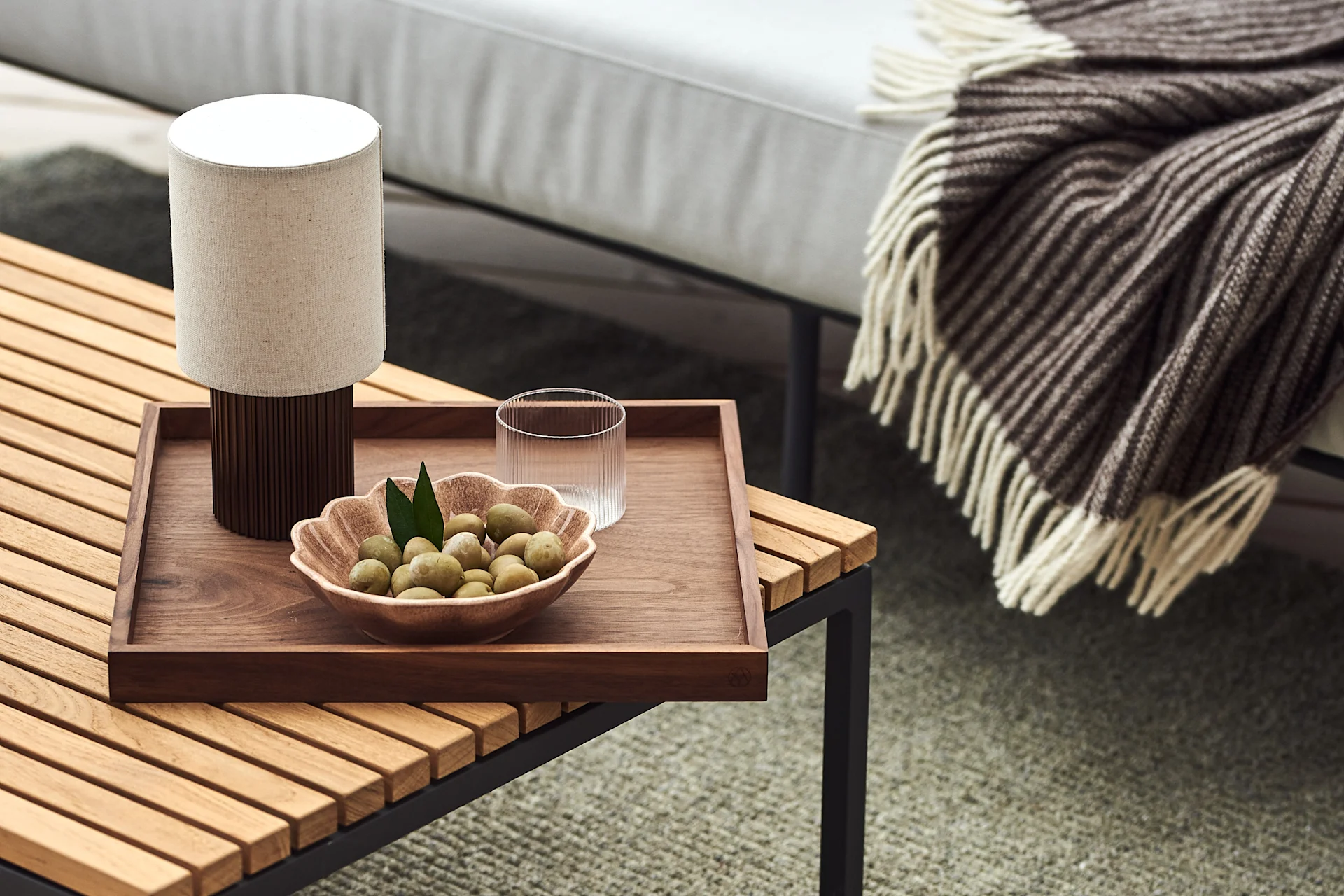 Decorate your balcony with portable lighting and cosy textiles to enjoy the cooler, longer evenings. 