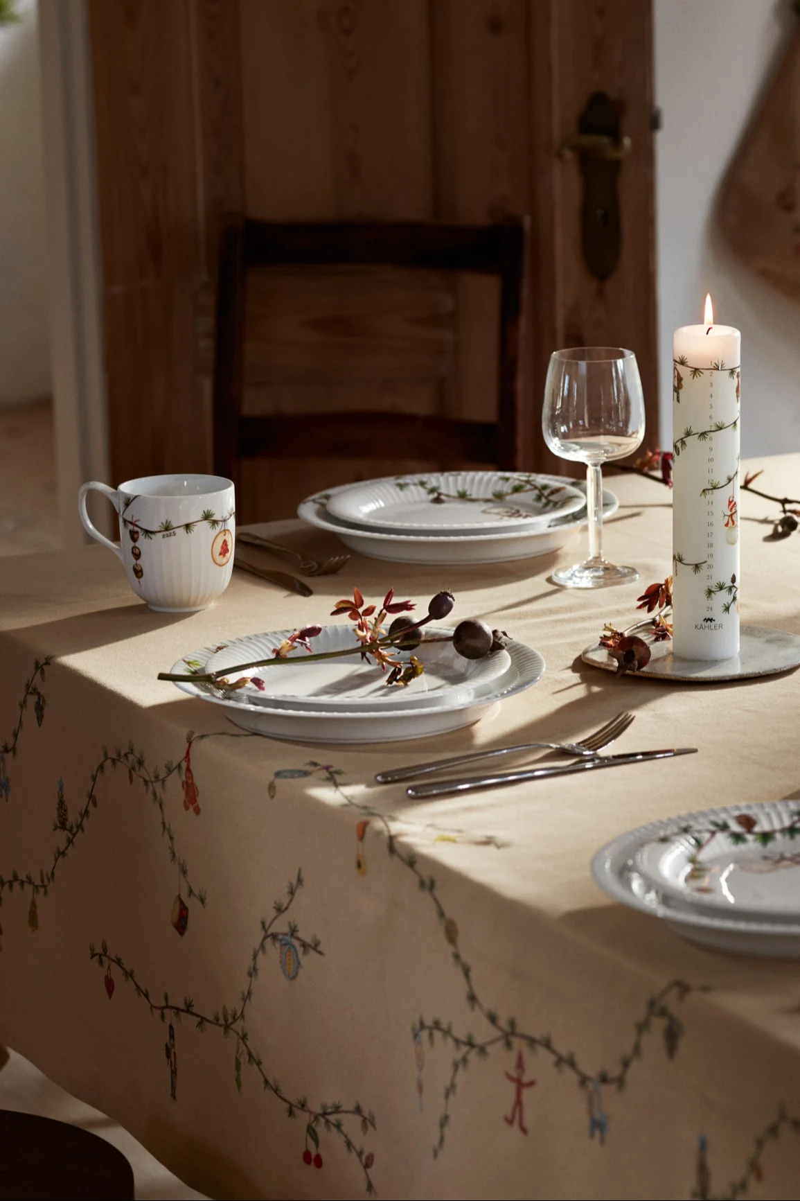 A festive table set with Christmas tableware and the Hammershøi tablecloth from Kähler.