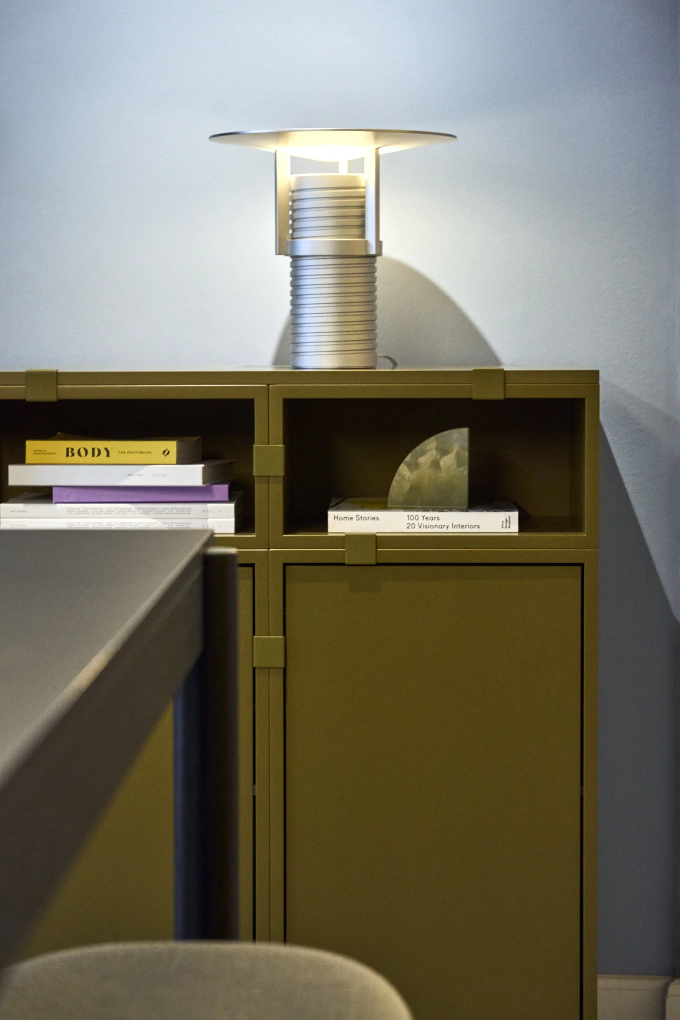 A green shelf, built from the Stacked collection, with the silver Set table lamp on top, all from Muuto.