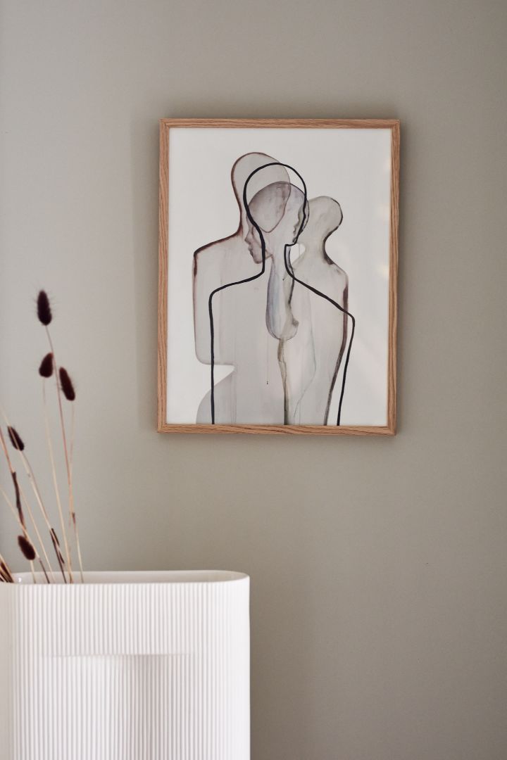 Posters are one of the autumn interior design trends for 2021, we love the Mother poster from Paper Collective hanging on a beige wall behind the beige Ridge vase from Muuto.