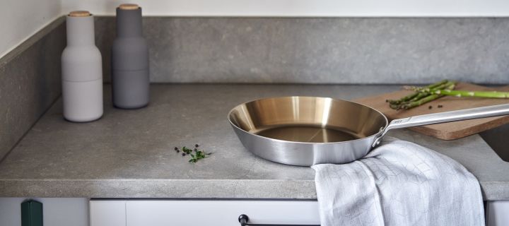 Renew your kitchen with 11 practical & stylish kitchen accessories for easier cooking - here you see the stylish Fiskars frying pan in stainless steel together with the fine Swedish Grace Mist kitchen towel from Rörstrand.