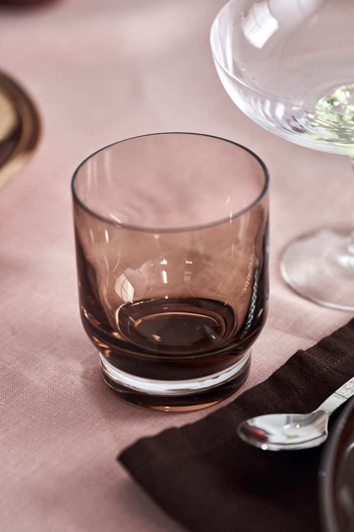 Coloured glass like the Lungo drinking glass from Blomus look luxurious against a pink tablecloth in the Boost tablescape.