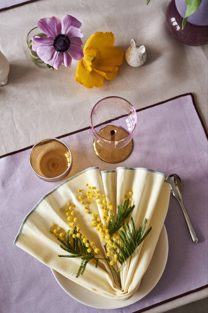 Create a festive Easter table setting in the spring pastels with Contour yellow cloth napkin and purple placemat from HAY.