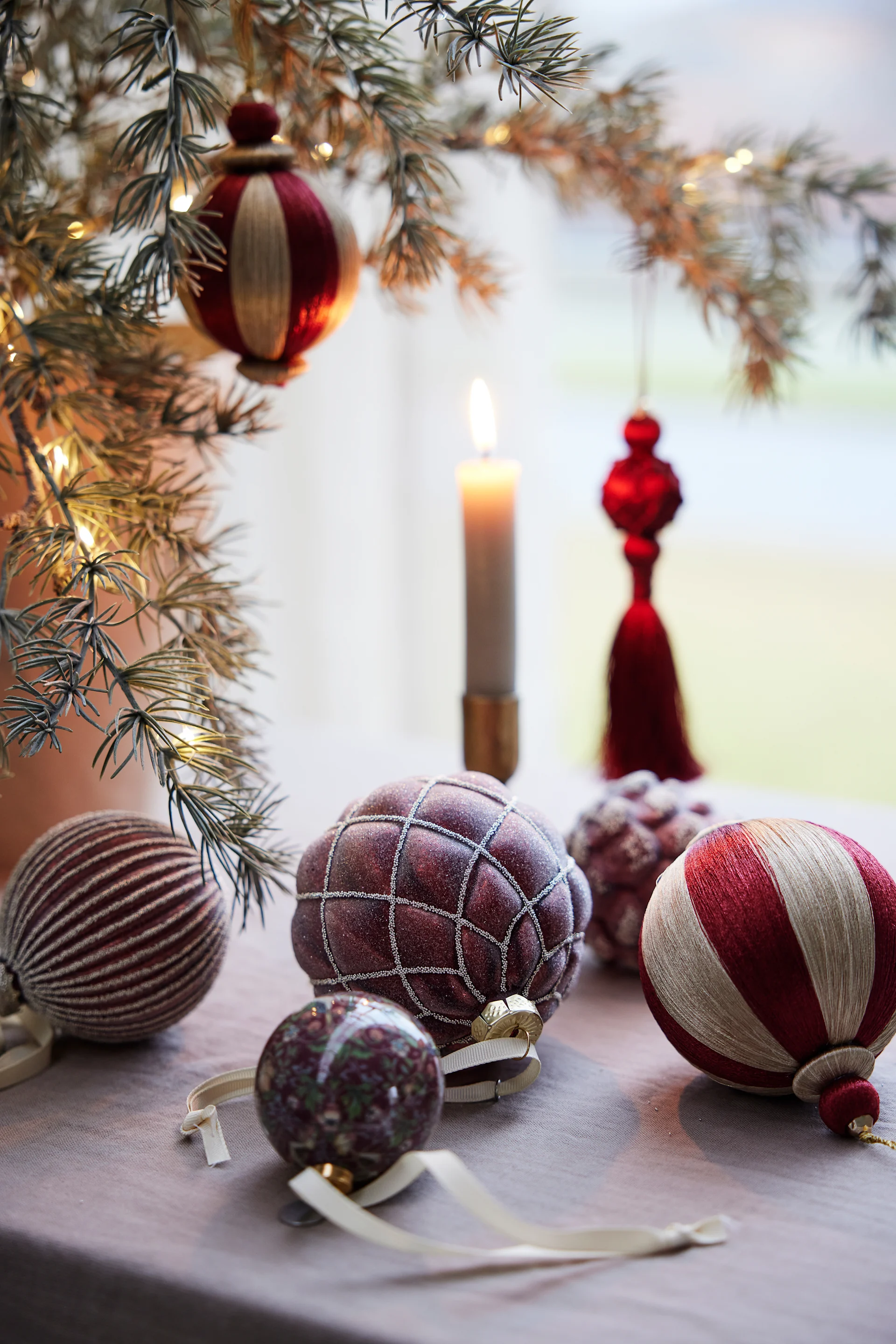 Various Christmas baubles by Lene Bjerre are displayed as Christmas decorations on a table.