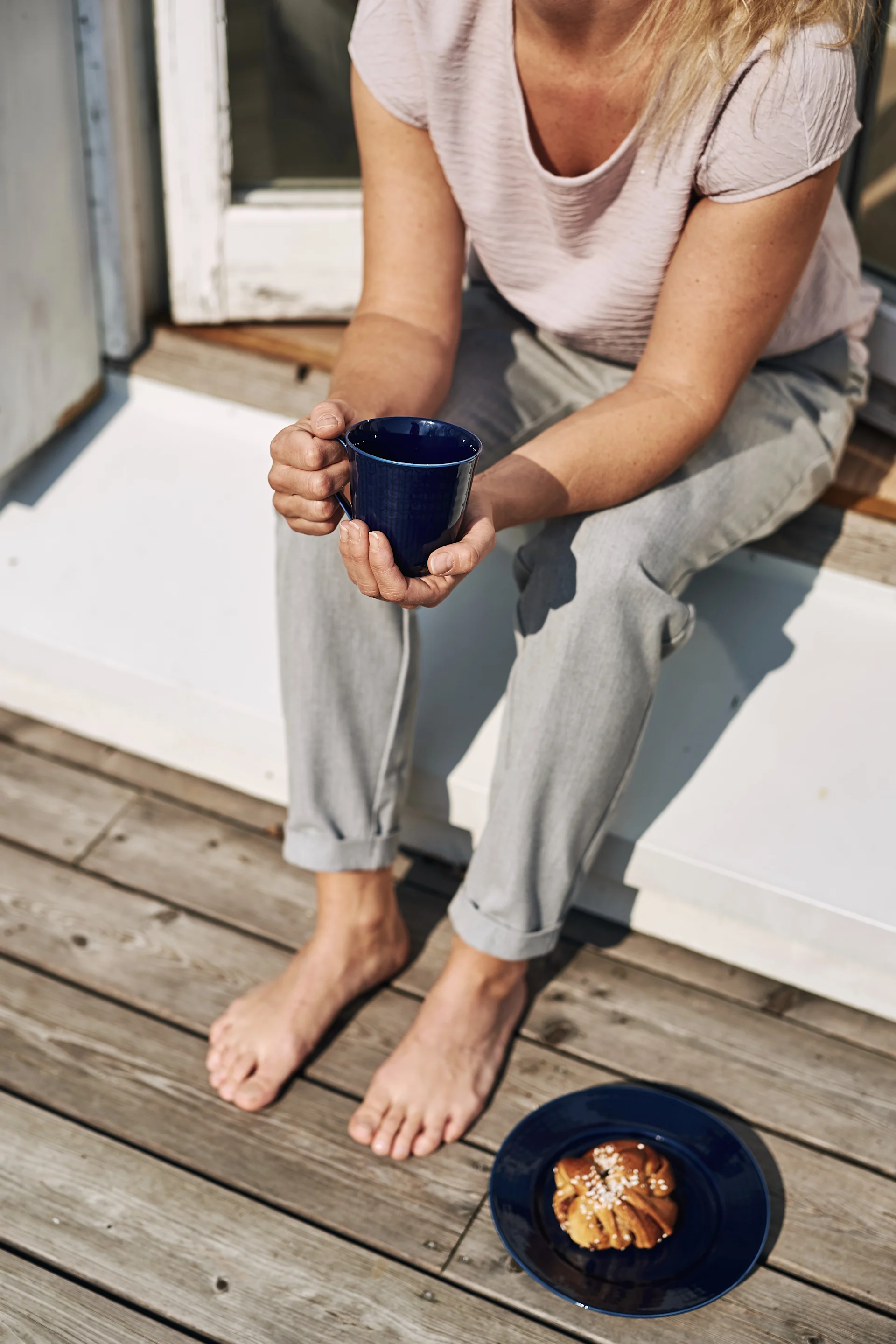 Enjoying a Swedish fika in the sunshine with the Swedish Grace mug and plate in midnight blue.
