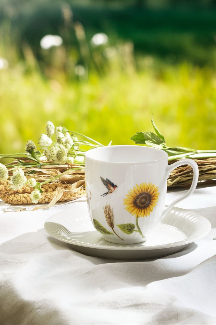 The Hammershoi summer collection sunflower mug stands on a table in the sunshine. 
