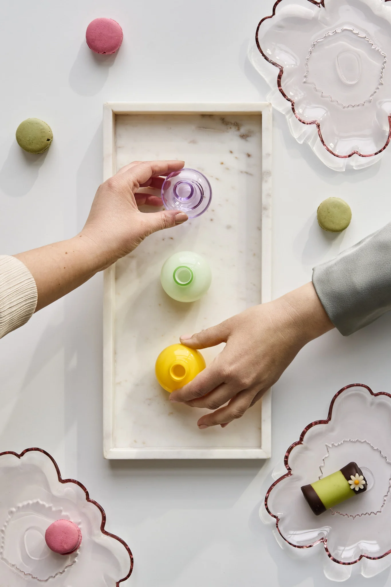 Hands grab mini vases in various colours to take home as party favours. Discover how to throw a party with an unforgettable atmosphere.  