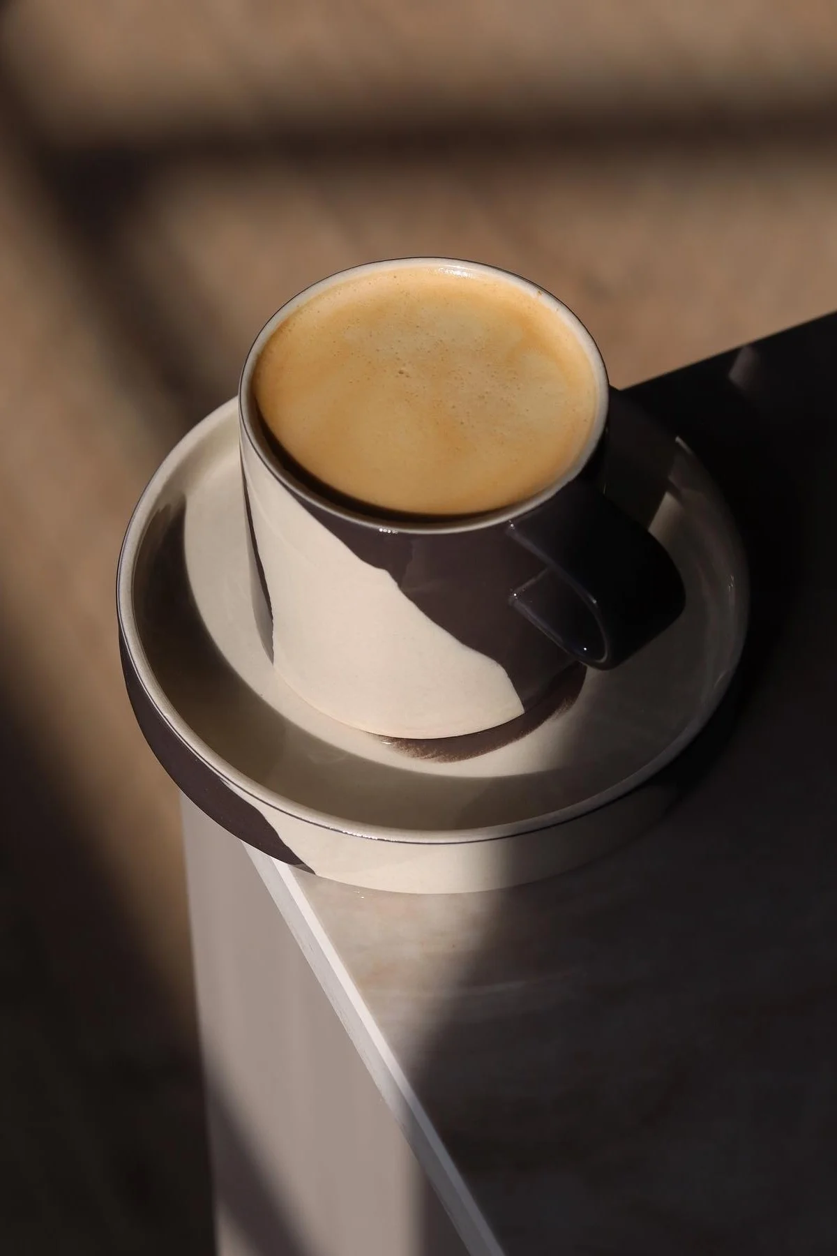 The black and white patterned inlay mug from Ferm Living stands on a table corner in @saraelineeriksen's home..