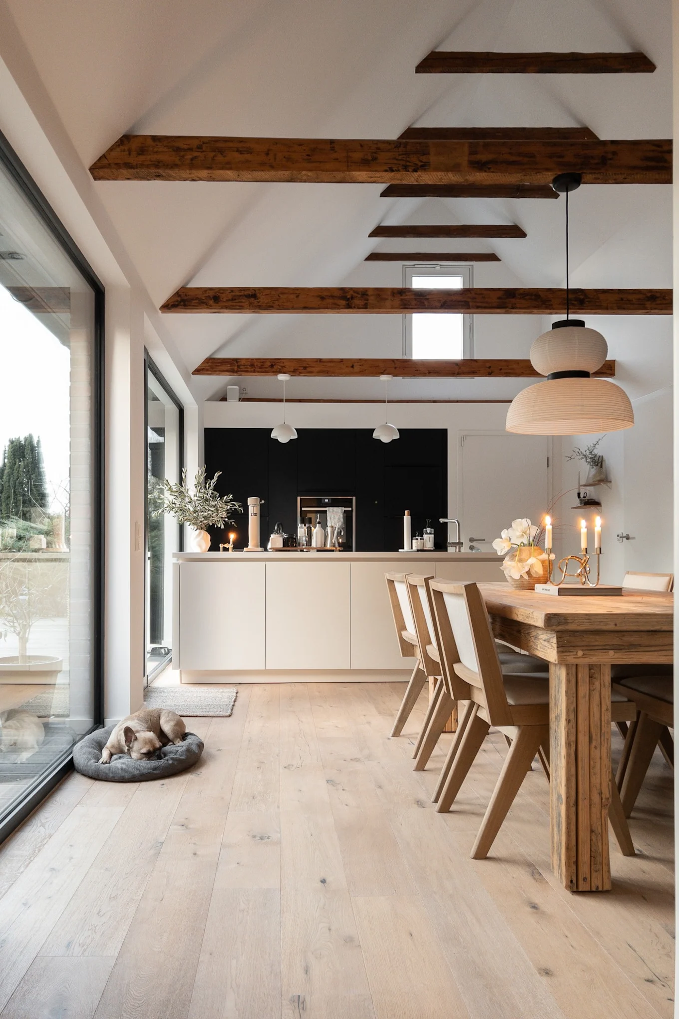 Create a Scandinavian home with @haus_tannenkamp, here you see the Formakami rice paper lamp hanging over a dining table in a large open space with lots of natural materials.