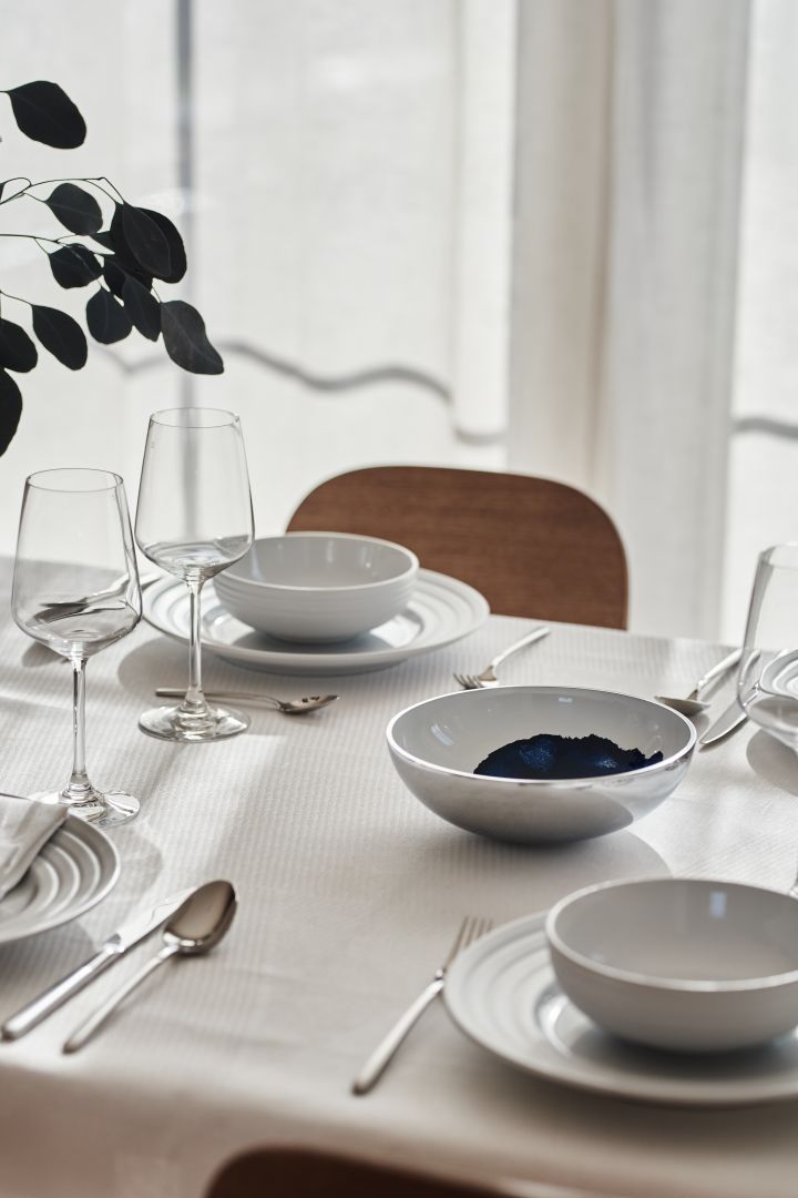 A white table setting with porcelain from NJRD and linen napkins and tablecloth from Scandi Living. 