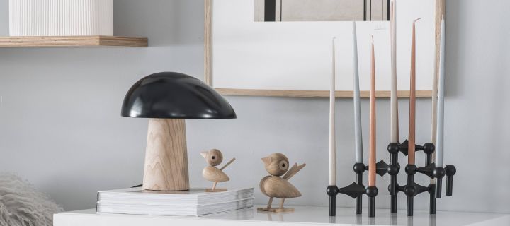 Fritz Hansen Night Owl lamp in oak with Stoff candleholder in black on a sideboard in a Scandinavian living room. 