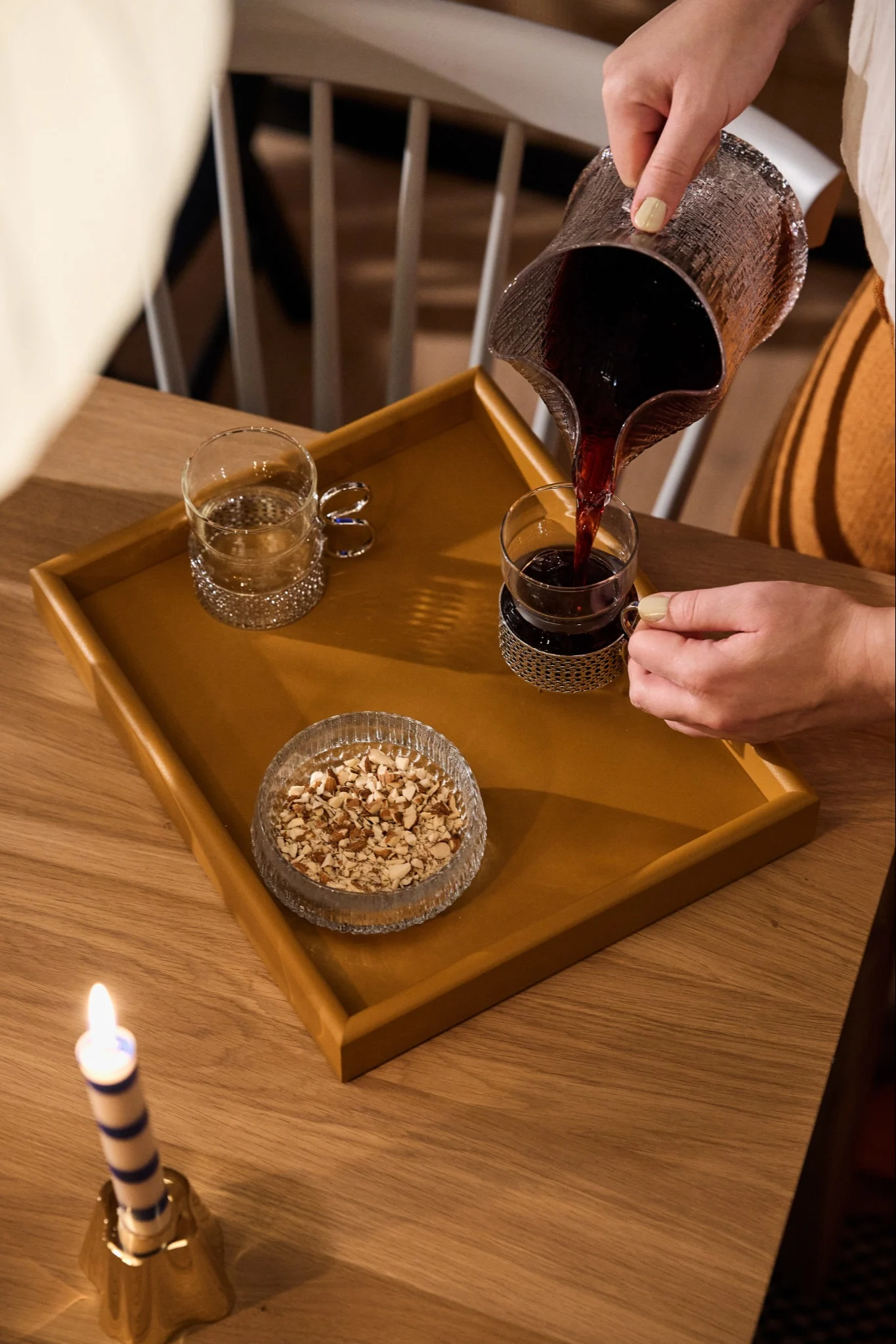 Someone pours mulled wine into the Tsaikka glasses from Iittala, these retro glasses add a vintage touch to any vintage Christmas decor.