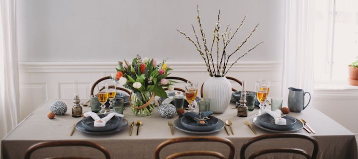 An Easter table setting with a rustic touch from Nordic Sea porcelain by Broste Copenhagen and brass coloured cutlery.