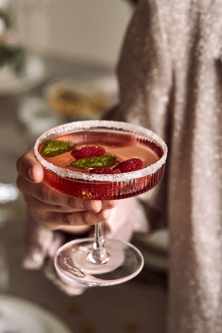 New year party ideas - here you see someone holding a raspberry cocktail in the Ripple champagne glass from ferm LIVING.