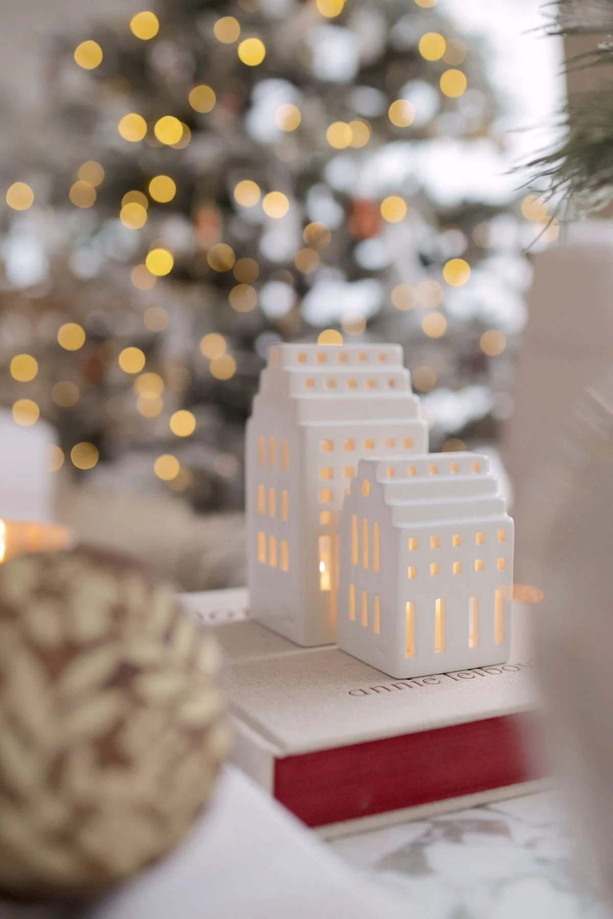 Decorate with traditional Scandinavian Christmas decorations like the Urbania candle holders from Kähler. Here you see a collection of them in the windowsill with a young boy. 