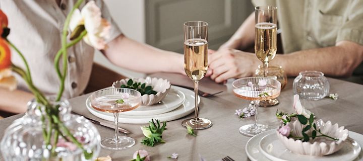 A romantic table setting with plates and bowls from By On together with elegant champagne glasses from Blomus.