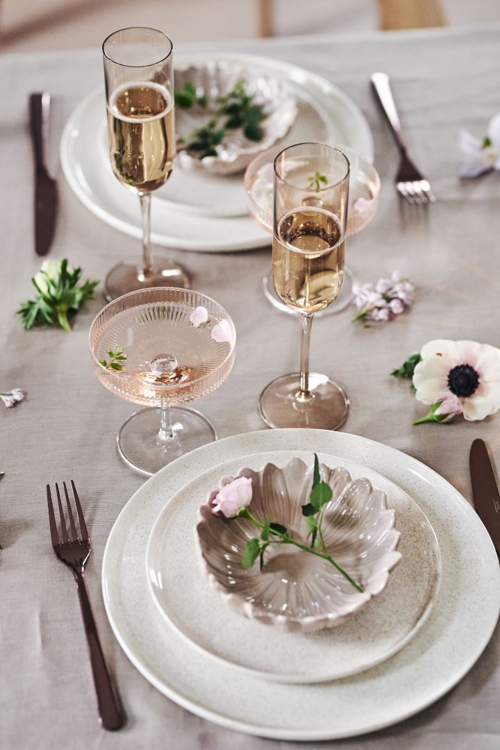 An elegant and romantic table setting idea with playful bowls from By On and delicate champagne and cocktail glasses like the ripple glass from Ferm Living. 