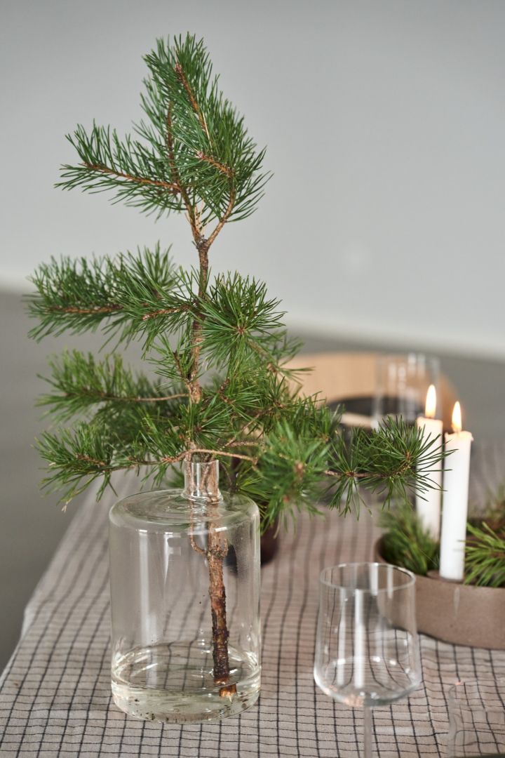 The pipe glass vase from DBKD with a green sprig on the Cultive Christmas tablescape. 