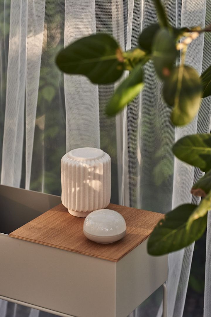 The battery powered cordless table lamp Norrsken from By On in a greenhouse next to the Soft Spot from Rosendahl. 
