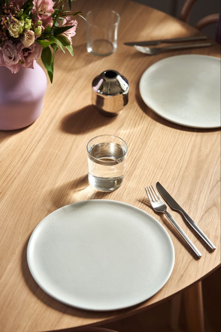 An overhead shot of a place setting with a simple white plate and the lilac Dorotea vase for Gense. 