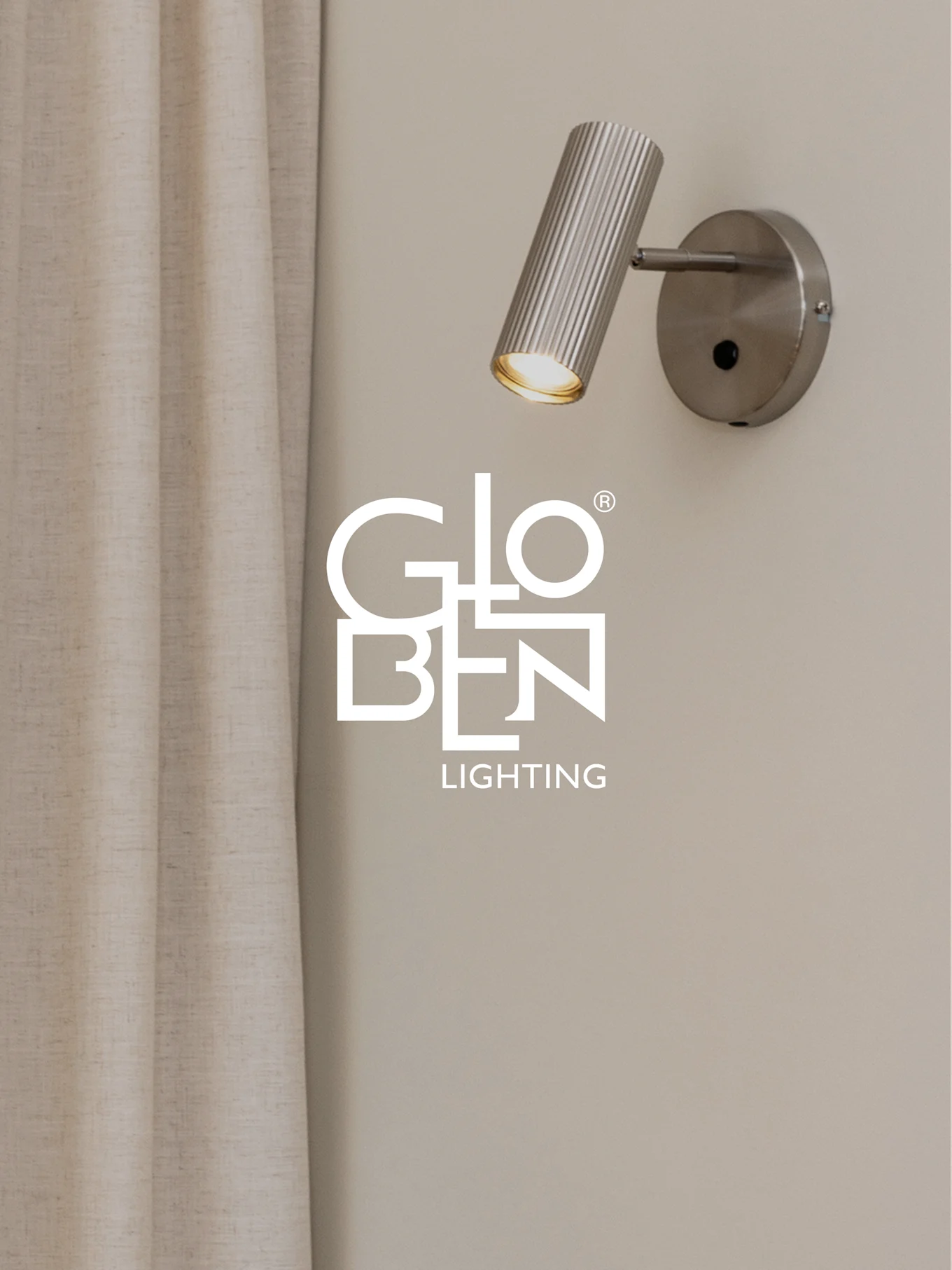 A brushed metal, ribbed wall spotlight with a warm glow, next to a light curtain, with the Globen Lighting logo.