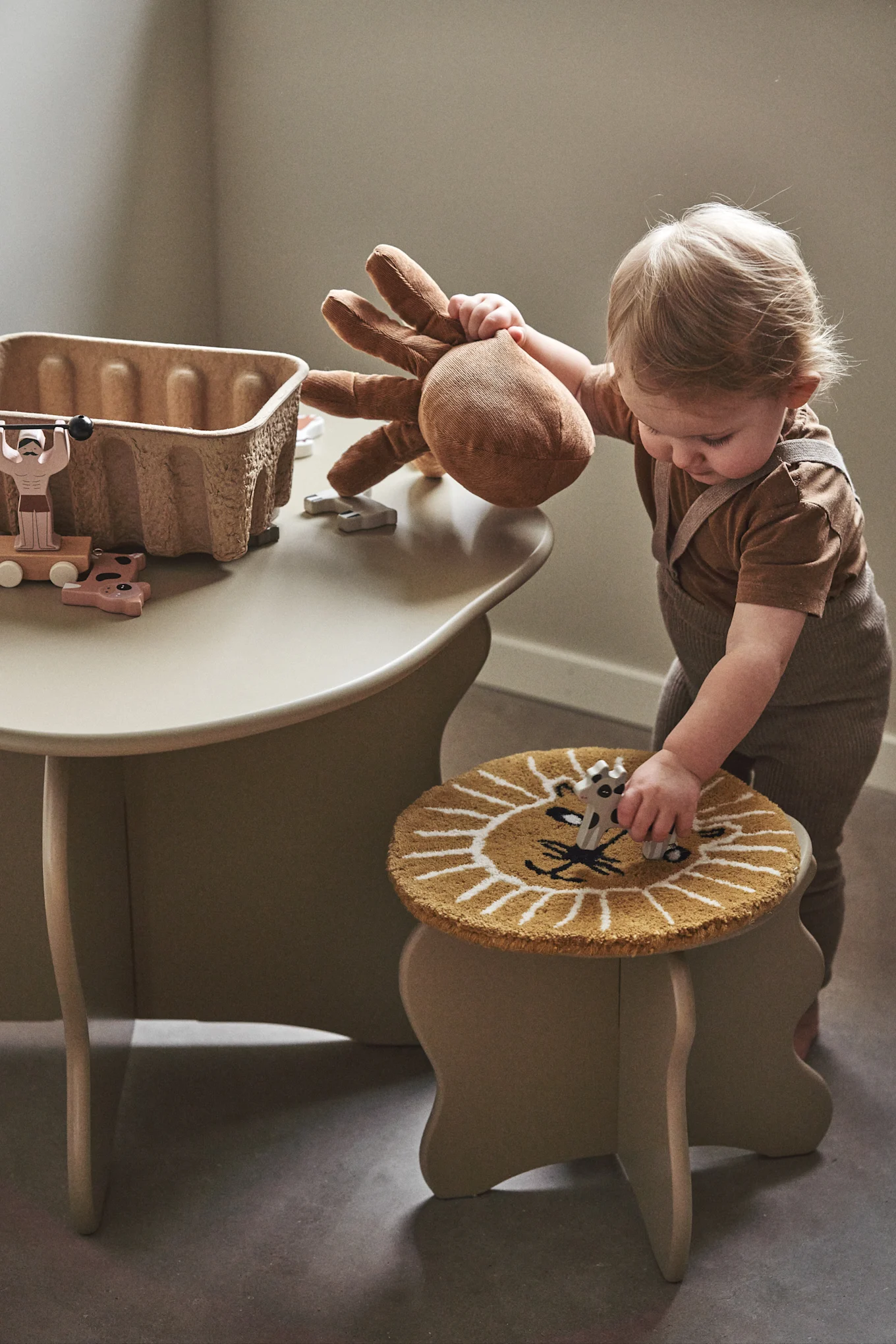 A small table and chairs is a must have in a children's room, here you see a small child with the slope table and stool from Ferm Living. 