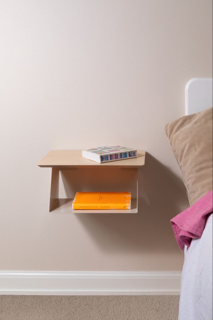 The Edgy bedside table from Maze with a bright orange book and pink towel. 