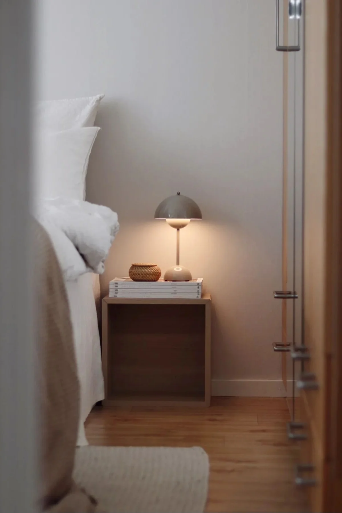 The cordless table lamp Lucca from &Tradition is carried on a beach.