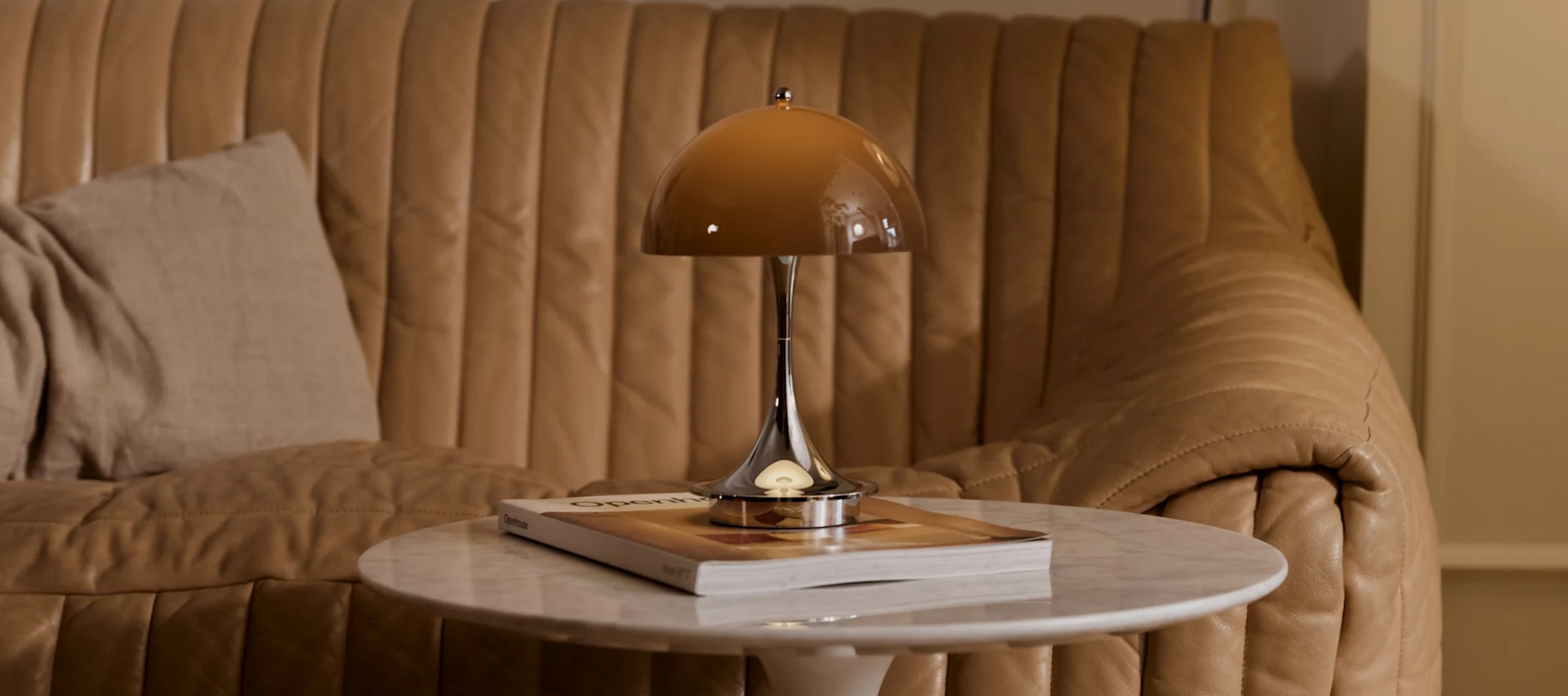 A side table with a brown Panthella table lamp, showcasing the interior colour trends of 2026.