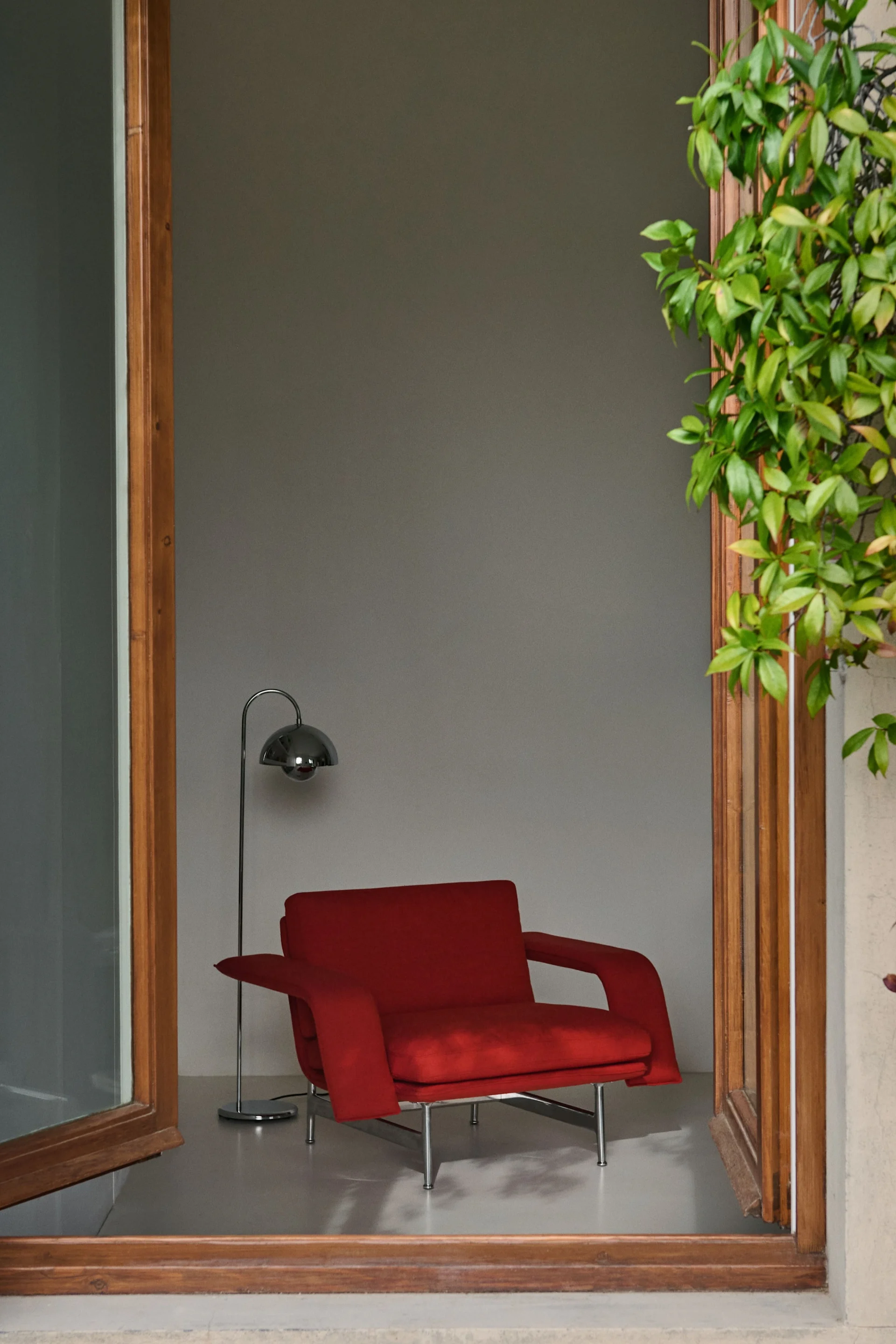The 60s and 70s are experiencing a revival with the interior trends of autumn 2025. Here, the red Meantime lounge chair from &tradition stands in an open window.