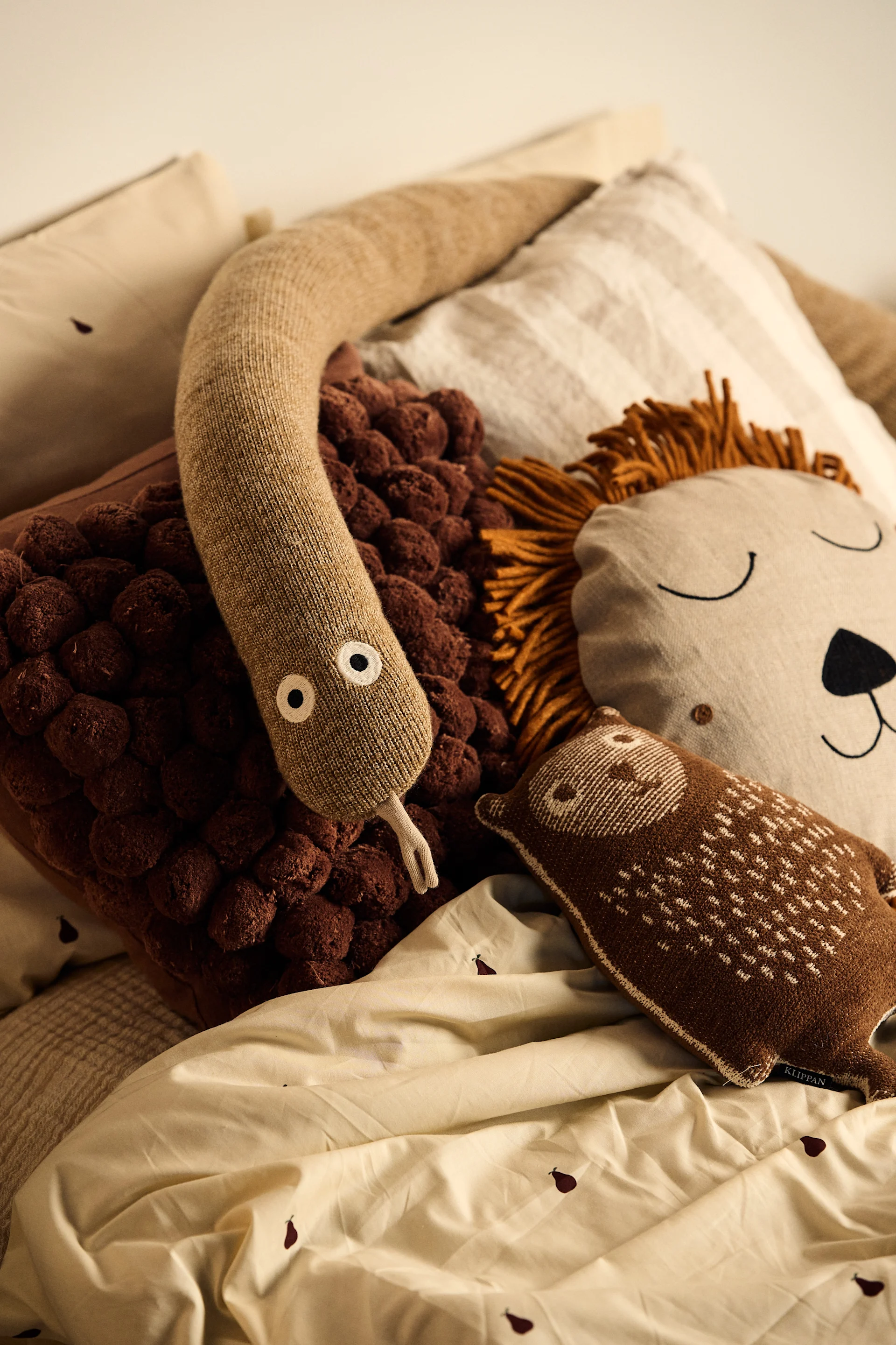 Be sure to include playful decorations in your children's room. Here you see a snake and a lion pillow on a child's bed. 
