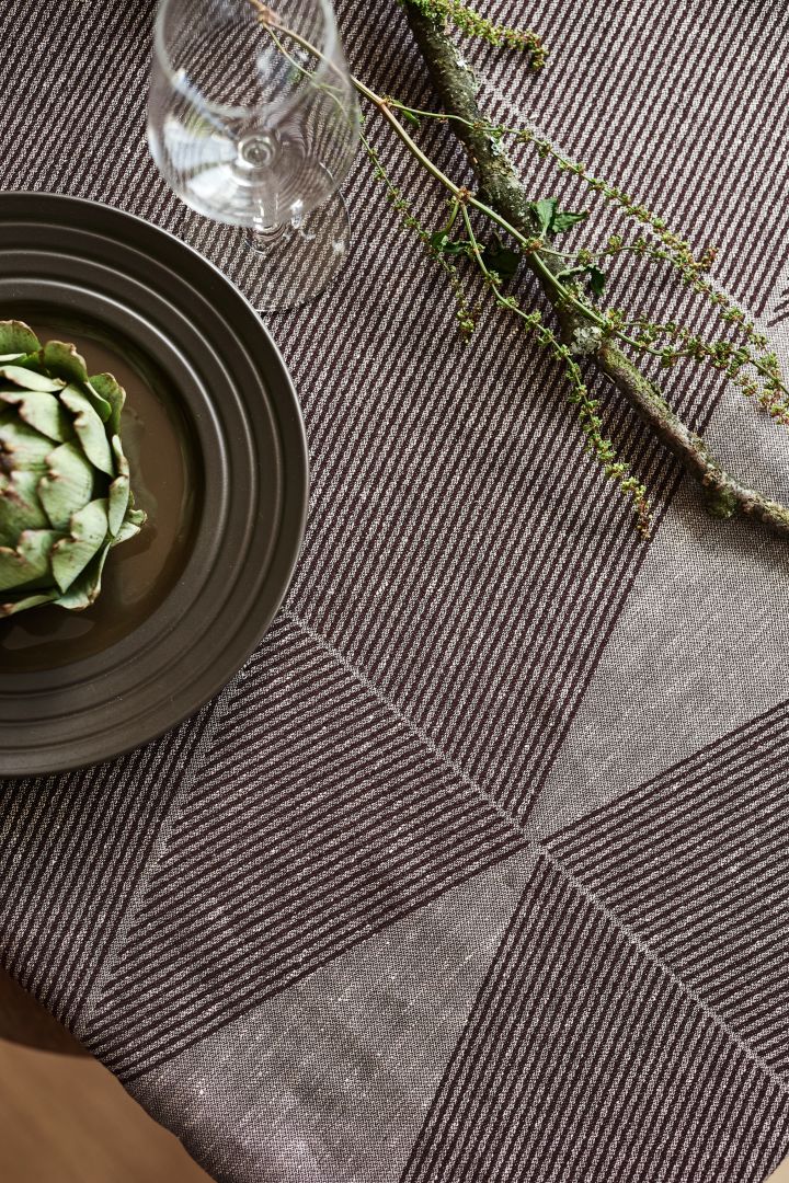 The Geometric tablecloth from NJRD in brown with a brown lines plate and a green artichoke. 
