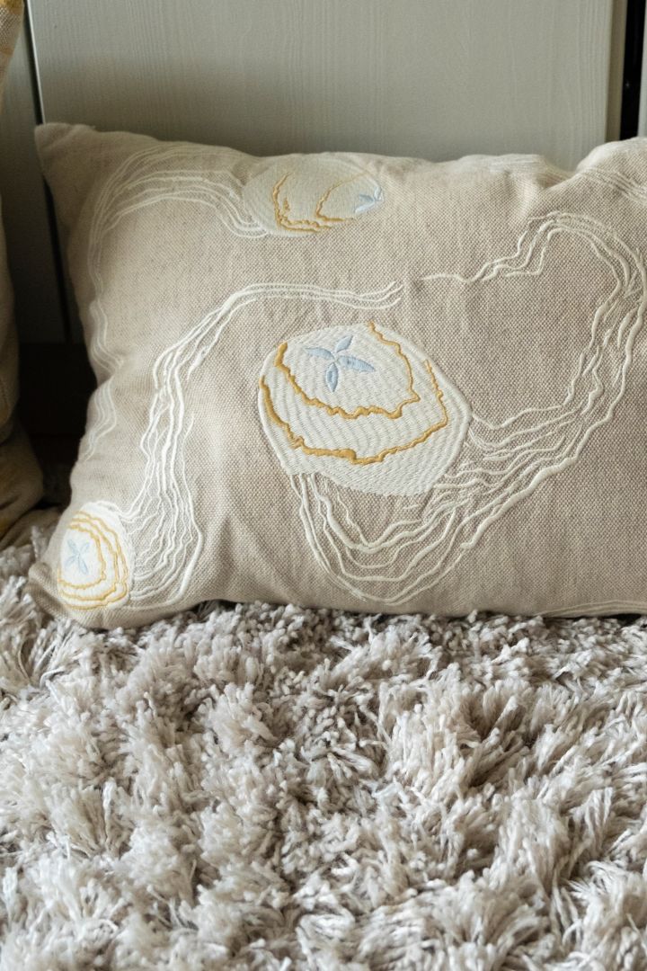 The embroidered pillow from Fine Little Day shows a jelly fish motif with a hint of blue, fitting perfectly into the Scandinavian interior design trends for 2023.