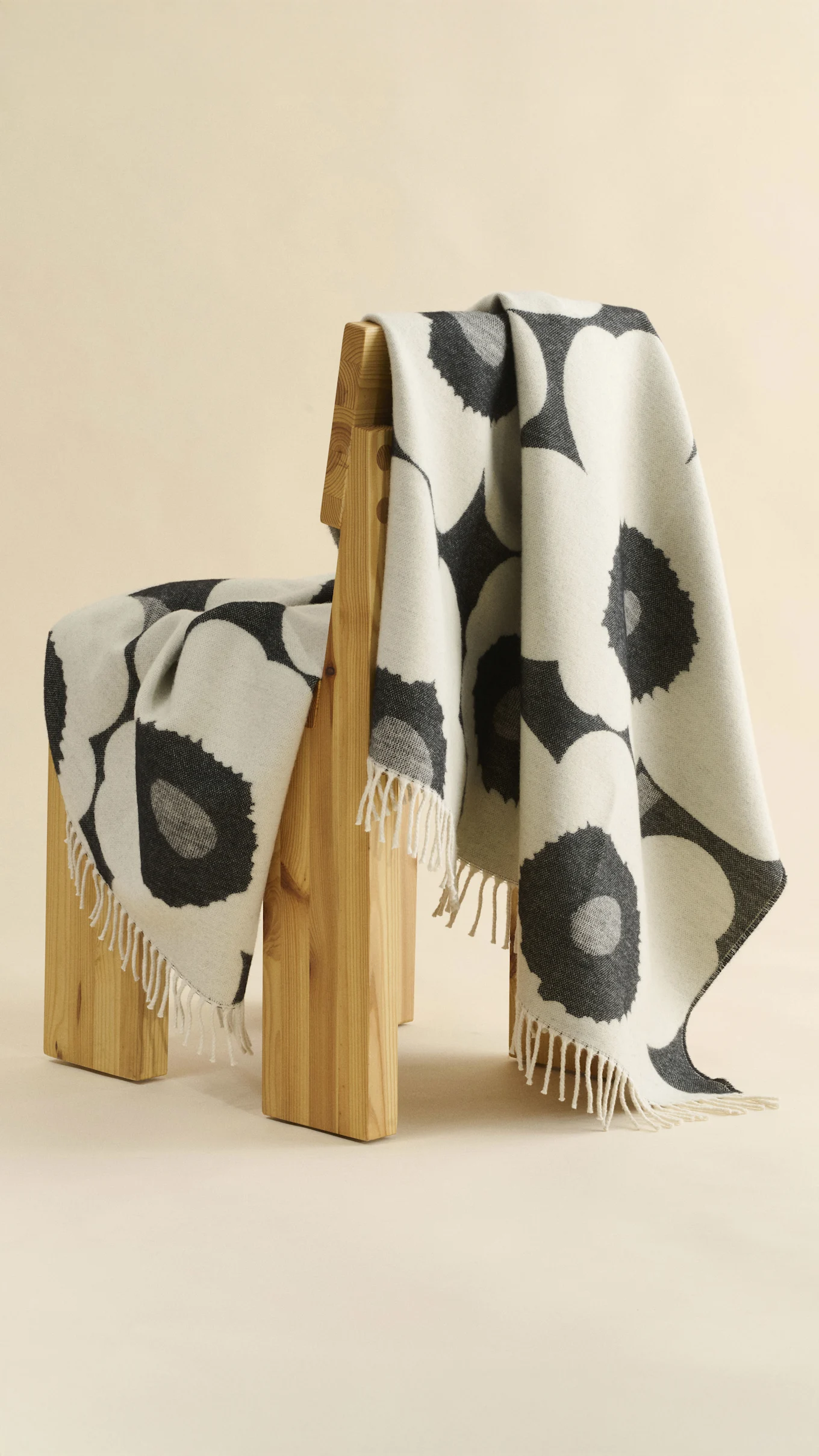 Marimekko blue and off-white striped towel draped over a grey stand, with soap in a dish and a floral rug in the background.