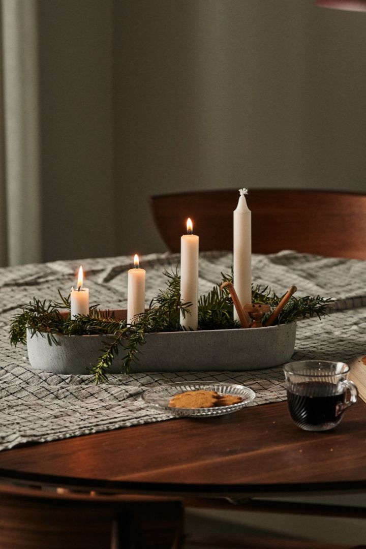 Here you see a traditional Scandinavian Christmas candle holder on the table with gingerbread and a cup of mulled wine. 
