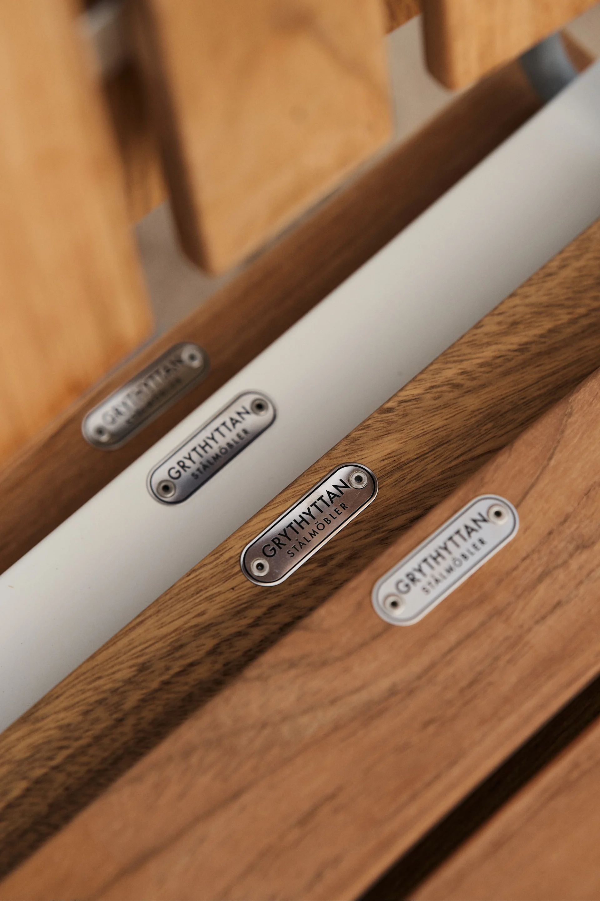 The A2 chair from Grythyttan Stålmöbler is an icon among outdoor furniture in teak, here a detail image of the seat where the logo in galvanised steel sits like a beautiful detail.